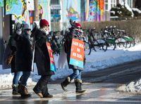 Teachers of the Elementary Teachers' Federation of Ontario wave to honking cars as they participate in a full withdrawal of services strike in Toronto on Jan. 20, 2020.