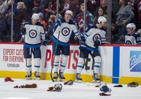 Jan 6, 2022; Denver, Colorado, USA; Winnipeg Jets defenseman Nathan Beaulieu (28) and defenseman Logan Stanley (64) react as fans throw hats onto the ice during the third period after Colorado Avalanche left wing Gabriel Landeskog scored a hat trick in at Ball Arena.  Mandatory Credit: John Leyba-USA TODAY Sports