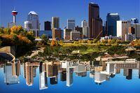 Photo illustration: Downtown Calgary from Bow River near Zoo. Calgary urban scenic with buildings, including Calgary Tower, Bankers Hall, and the Petro Canada building reflected in the Bow River. Calgary is the largest city in the western province of Alberta.