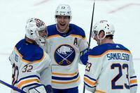 Buffalo Sabres defenceman Mark Pysyk (centre) and defenceman Mattias Samuelsson celebrate with Michael Houser after defeating the Ottawa Senators in NHL action, Tuesday, January 18, 2022 in Ottawa.  THE CANADIAN PRESS/Adrian Wyld
