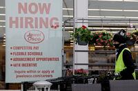 A man pushes carts as a hiring sign shows at a Jewel Osco grocery store in Deerfield, Ill., Thursday, April 23, 2020. Friday, Dec. 4,  monthly U.S. jobs report will help answer a key question hanging over the economy: Just how much damage is being caused by the resurgent coronavirus, the resulting restrictions on businesses and the reluctance of consumers to shop, travel and dine out? (AP Photo/Nam Y. Huh)
