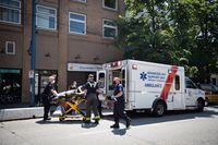 Paramedics and firefighters place a man in an ambulance after responding to an SRO in the Downtown Eastside during a heat wave in Vancouver, on Tuesday, June 29, 2021. Darryl Dyck/The Globe and Mail