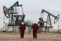 FILE PHOTO: Workers walk as oil pumps are seen in the background in the Uzen oil and gas field in the Mangistau Region of Kazakhstan November 13, 2021. Picture taken November 13, 2021. REUTERS/Pavel Mikheyev/File Photo