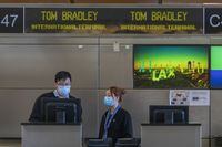 LOS ANGELES, CA - FEBRUARY 02: Air China employees wear medical masks for protection against the novel coronavirus outbreak at LAX Tom Bradley International Terminal on February 2, 2020 in Los Angeles.