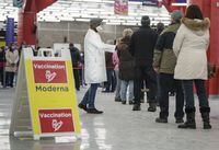 People line up to enter a COVID-19 vaccination clinic in Montreal on Thursday, January 6, 2022. THE CANADIAN PRESS/Paul Chiasson