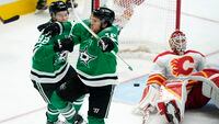 Dallas Stars' Joe Pavelski (16) and Vladislav Namestnikov (92) celebrate a after Pavelski scored against Calgary Flames goaltender Jacob Markstrom (25) during the third period of Game 3 of an NHL hockey Stanley Cup first-round playoff series Saturday, May 7, 2022, in Dallas. The Stars won 4-2. (AP Photo/Tony Gutierrez)