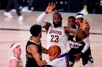 Los Angeles Lakers' LeBron James, centre, and Alex Caruso, left, defend as Denver Nuggets guard Jamal Murray  attempts to pass the ball during the second half of Game 3 on Sept. 22, 2020.