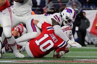 Buffalo Bills defensive end Shaq Lawson, top, takes down New England Patriots quarterback Mac Jones (10) during the first half of an NFL football game, Thursday, Dec. 1, 2022, in Foxborough, Mass. (AP Photo/Michael Dwyer)