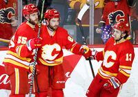 Calgary Flames' Dillon Dube, centre, celebrates his goal with teammates Noah Hanifin, left, and Johnny Gaudreau during second period NHL hockey action against the New Jersey Devils in Calgary, Wednesday, March 16, 2022.THE CANADIAN PRESS/Jeff McIntosh
