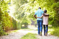 Rear View Of Mature African American Couple Walking In Countryside