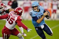 Toronto Argonauts quarterback Chad Kelly (12) protects the ball from Calgary Stampeders defensive lineman Julian Howsare (95) during first half CFL football action in Toronto on Friday, August 25, 2023. THE CANADIAN PRESS/Frank Gunn