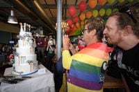 A supporter takes a picture with her mobile phone of a wedding cake following a nationwide referendum on same-sex marriage, in Swiss capital Bern on September 26, 2021. - Swiss voters have approved the government's plan to introduce same-sex marriage, according to the first projections following September 26 referendum triggered by opponents of the move. Shortly after the polls closed at noon market researchers GFS Bern, who conducted the main polling throughout the campaign, projected that the "yes" vote was heading for victory, which would bring the Alpine nation into line with most of western Europe. (Photo by Fabrice COFFRINI / AFP) (Photo by FABRICE COFFRINI/AFP via Getty Images)