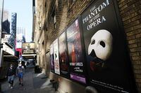 FILE - Broadway posters appear outside the Richard Rodgers Theatre during Covid-19 lockdown in New York on May 13, 2020. Broadway theaters will no longer demand audiences wear masks starting in July. (Photo by Evan Agostini/Invision/AP, File)