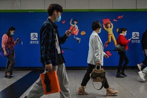 People walk past an advertisement for Alipay in a subway station in Shanghai on October 12, 2021. (Photo by Hector RETAMAL / AFP) (Photo by HECTOR RETAMAL/AFP via Getty Images)