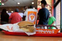 A chicken sandwich sits on a table at a Popeyes as guests wait in line in Kyle, Texas, on August 22, 2019. Restaurant Brands International Inc., the company behind Tim Hortons, Burger King and Popeyes, reported its third-quarter profit rose compared with its year ago as its revenue climbed more than 10 per cent. THE CANADIAN PRESS/AP, Eric Gay