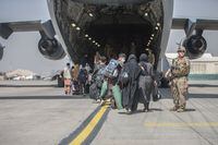 Families begin to board a U.S. Air Force C-17 Globemaster III transport plane during an evacuation at Hamid Karzai International Airport, Afghanistan, August 23, 2021. U.S. Marine Corps/Sgt. Samuel Ruiz/Handout via REUTERS.