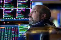 In this photo provided by the New York Stock Exchange, specialist James Denaro works at his post on the trading floor, Friday, March 11.