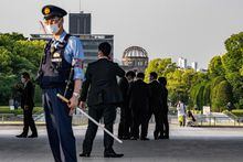 A police officer stands guard with the security personals at the Peace Memorial Park with the background of the Atomic Bomb Dome in Hiroshima, ahead of the G7 Leaders' Summit, on May 16, 2023. (Photo by Philip FONG / AFP) (Photo by PHILIP FONG/AFP via Getty Images)