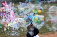 A street vendor blows soap bubbles for customers at his stall in Colombo, Sri Lanka January 12, 2021. REUTERS/Dinuka Liyanawatte