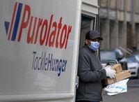 A Purolator driver wears a mask as he makes deliveries in Toronto on March 24, 2020.&nbsp;With online sales set to hit record highs this year, Statistics Canada says that wholesalers, rather than retailers, have benefited most from the trend toward online shopping. Statistics Canada says $85 billion of Canada?s $305 billion in online sales last year went to wholesalers, while transportation and warehousing companies got $60 billion, manufacturing was worth $38 billion, and retailers grossed $22 billion.THE CANADIAN PRESS/Frank Gunn