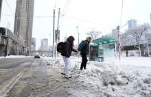 People walk across a snow covered street during a snow storm in Toronto, Saturday, March 4, 2023. Environment Canada has issued a winter storm warning for much of southern Ontario. 
