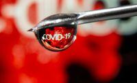 FILE PHOTO:The word "COVID-19" is reflected in a drop on a syringe needle in this illustration taken November 9, 2020. REUTERS/Dado Ruvic/Illustration/File Photo