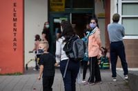 Wearing face masks to curb the spread of COVID-19, Karin Brodbeck drops her son Ricardo Brodbeck, 6, a Grade 1 student, off at Lynn Valley Elementary School in North Vancouver, B.C., Thursday, Sept. 9, 2021. THE CANADIAN PRESS/Darryl Dyck