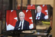 David Johnston, Independent Special Rapporteur on Foreign Interference, is pictured on the screens of translators as he presents his first report in Ottawa on Tuesday, May 23, 2023. THE CANADIAN PRESS/Sean Kilpatrick
