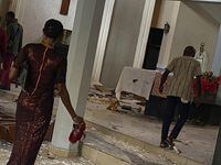 People walk in the St. Francis Catholic Church in Owo Nigeria, Sunday, June 5, 2022. Lawmakers in southwestern Nigeria say more than 50 people are feared dead after gunmen opened fire and detonated explosives at a church. Ogunmolasuyi Oluwole with the Ondo State House of Assembly said the gunmen targeted the St Francis Catholic Church in Ondo state on Sunday morning just as the worshippers gathered for the weekly Mass. (AP Photo/Rahaman A Yusuf)