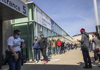 People line up outside an immunization clinic to get their Oxford-AstraZeneca COVID-19 vaccine in Edmonton, Tuesday, April 20, 2021. THE CANADIAN PRESS/Jason Franson