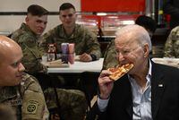 TOPSHOT - US President Joe Biden (R) eats a pizza as he meets with service members from the 82nd Airborne Division, who are contributing alongside Polish Allies to deterrence on the Alliances Eastern Flank, in the city of Rzeszow in southeastern Poland, around 100 kilometres (62 miles) from the border with Ukraine, on March 25, 2022. (Photo by Brendan SMIALOWSKI / AFP) (Photo by BRENDAN SMIALOWSKI/AFP via Getty Images) *** BESTPIX ***