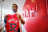 Toronto RaptorsÕ recently signed free agent Otto Porter Jr. poses with his jersey following a press conference at the Raptors practice facility in Toronto, Wed. July 6, 2022. THE CANADIAN PRESS/Cole Burston