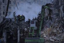 Rescue workers clear the rubble from an apartment building that was destroyed in a Russian rocket attack at a residential neighbourhood in the southeastern city of Dnipro, Ukraine, Sunday, Jan. 15, 2023. The death toll from a Russian missile strike on an apartment building in Dnipro rose to 25 Sunday, President Volodymyr Zelenskyy reported as rescue workers scrambled to pull survivors from the rubble. (AP Photo/Evgeniy Maloletka)