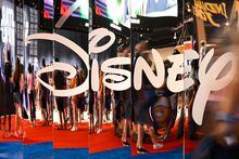 (FILES) In this file photo taken on September 09, 2022 attendees are reflected in Disney+ logo during the Walt Disney D23 Expo in Anaheim, California. - Disney's streaming service saw its first ever fall in subscribers last quarter, company data showed on February 8, 2023, as consumers cut back on spending amid higher costs and a souring global economy. Disney CEO Bob Iger on February 8, 2023, announced that the company would lay off 7,000 workers, in the veteran executive's first major decision since returning to lead the company in November. (Photo by Patrick T. FALLON / AFP) (Photo by PATRICK T. FALLON/AFP via Getty Images)