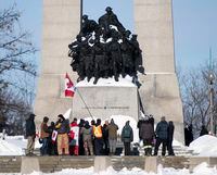 People surround the Tomb of the Unknown Soldier at the National War Memorial during a rally against COVID-19 restrictions in Ottawa, which began as a cross-country convoy protesting a federal vaccine mandate for truckers, on Sunday, Jan. 30, 2022. THE CANADIAN PRESS/Justin Tang
