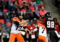 BC Lions quarterback Michael Reilly (13) throws the ball past the reach of Ottawa Redblacks defensive lineman Avery Ellis (98) during first half CFL football action in Ottawa on Saturday, Aug. 28, 2021. THE CANADIAN PRESS/Justin Tang