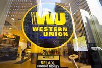 Midtown buildings are reflected in the window of a Western Union store in New York on April 5, 2016.