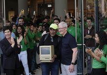 An unidentified person holding an old Macintosh Classic machine poses with Apple CEO Tim Cook for a photograph during the grand opening of Apple Inc. first flagship store in Mumbai, India, Tuesday, April 18, 2023. Apple Inc. is set to open its first flagship store in India in a much-anticipated launch Tuesday that highlights the company's growing aspirations to expand in the country it also hopes to turn into a potential manufacturing hub. (AP Photo/Rafiq Maqbool)