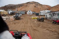 An all-terrain vehicle drives near the old Hudson Bay buildings in Kimmirut, Nunavut on October 11, 2021.