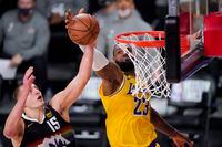 Denver Nuggets' Nikola Jokic (15) and Los Angeles Lakers' LeBron James (23) reach for a rebound during the first half of an NBA conference final playoff basketball game Thursday, Sept. 24, 2020, in Lake Buena Vista, Fla. (