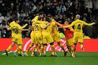 Barcelona's players celebrate after scoring a goal during the Spanish League football match between Real Madrid CF and FC Barcelona at the Santiago Bernabeu stadium in Madrid on March 20, 2022. (Photo by PIERRE-PHILIPPE MARCOU / AFP) (Photo by PIERRE-PHILIPPE MARCOU/AFP via Getty Images)