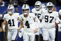 Las Vegas Raiders quarterback Derek Carr (4) and teammates run onto the field before an NFL football game against the Indianapolis Colts, Sunday, Jan. 2, 2022, in Indianapolis. (AP Photo/AJ Mast)