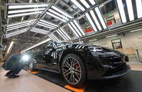 Employees of German car manufacturer Porsche AG inspect the quality of the varnish of Taycan full-electric sports cars under a light channel at the end of the assembly line at the production site in Stuttgart, southern Germany, on Sept. 26.