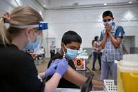 Samekh Nadeem, 12 (R) watches as his brother Sion Nadeem, 13, receives his Pfizer BioNTech COVID-19 vaccination at a clinic at the Embassy Grand Convention Centre in Brampton, Ont. on May 25, 2021. Fred Lum/The Globe and Mail.  