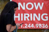(FILES) In this file photo a woman walks by a "Now Hiring" sign outside a store on August 16, 2021 in Arlington, Virginia. - American firms hired just 374,000 more workers in August, according to payroll services firm ADP, a slight increase over July but far less than economists had expected. The data "has highlighted a downshift in the labor market recovery," ADP chief economist Nela Richardson said."We have seen a decline in new hires, following significant job growth from the first half of the year." (Photo by Olivier DOULIERY / AFP) (Photo by OLIVIER DOULIERY/AFP via Getty Images)