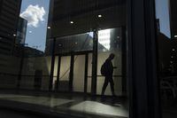 A new report says as the corporate sector prepares for a possible recession, pledges made by companies to support diversity are at risk. A person walks though a downtown Toronto office building with other buildings reflected in a window in this June 11, 2019 photo. THE CANADIAN PRESS/Graeme Roy
