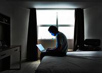 Man sitting in bed with a laptop