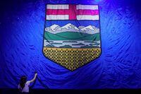 A worker irons a giant Alberta flag while getting the stage ready for the United Conservative Party (UCP) provincial election night party in Calgary, Alberta, Canada May 29, 2023. REUTERS/Todd Korol