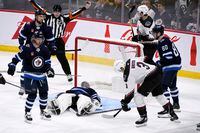 Winnipeg Jets goaltender Connor Hellebuyck (37) covers up a rebound against the Arizona Coyotes during third period NHL action in Winnipeg on Sunday January 15, 2023. THE CANADIAN PRESS/Fred Greenslade