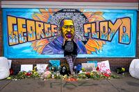 FILE - Damarra Atkins pays respect to George Floyd at a mural at George Floyd Square in Minneapolis, April 23, 2021. Minneapolis will buy the boarded-up Speedway gas station at George Floyd Square, the City Council decided unanimously on Thursday, Dec. 8, 2022. The area has become a protest site since Floyd, a Black man, was killed there by a white police officer in May 2020, sparking a national reckoning on racial injustice. (AP Photo/Julio Cortez, File)